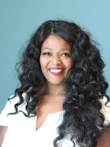 African American woman with bright smile and long curly hair.