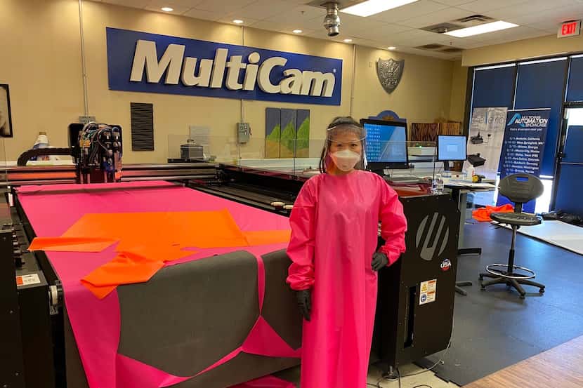 A MultiCam employee models one of their new reusable/washable hospital gowns, which they've...