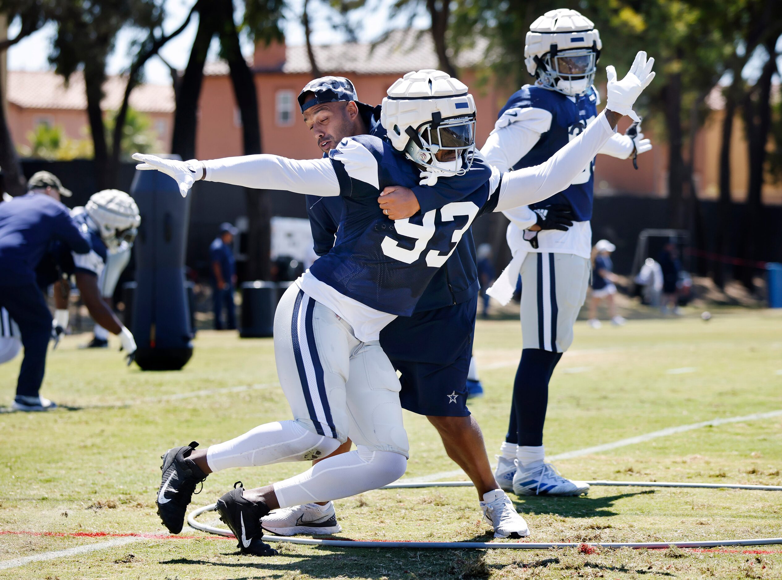 Dallas Cowboys defensive tackle Tarell Basham (93) ) is fought off by defensive line coach...