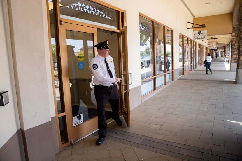 Jonathan Crisp, a security director with Allied Universal, looks around as he walks out of a...