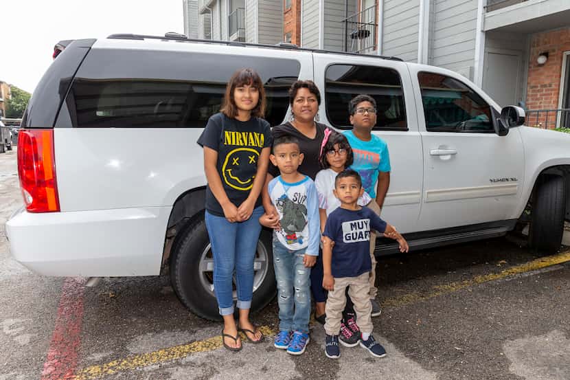 Lily de la Cruz with five of her children and the vehicle they lived in for part of 2020.