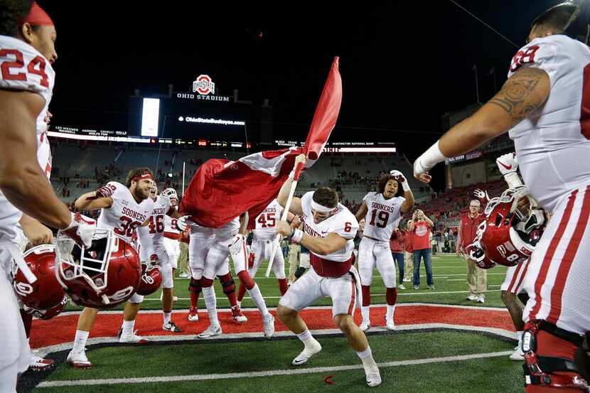 Oklahoma quarterback Baker Mayfield (6) plants the Sooner flag in the Ohio State logo at...