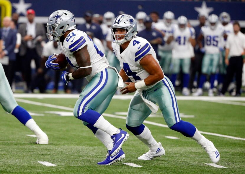 Dallas Cowboys running back Ezekiel Elliott (21) takes the ball from quarterback Dak...