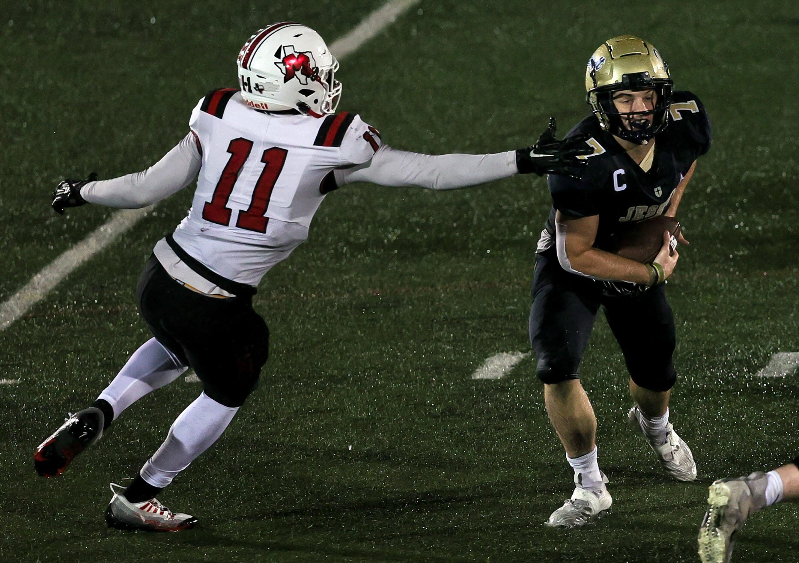 Jesuit wide receiver Jake Musso (7) avoids MacArthur defensive end Nagatcha Ariel (11)...