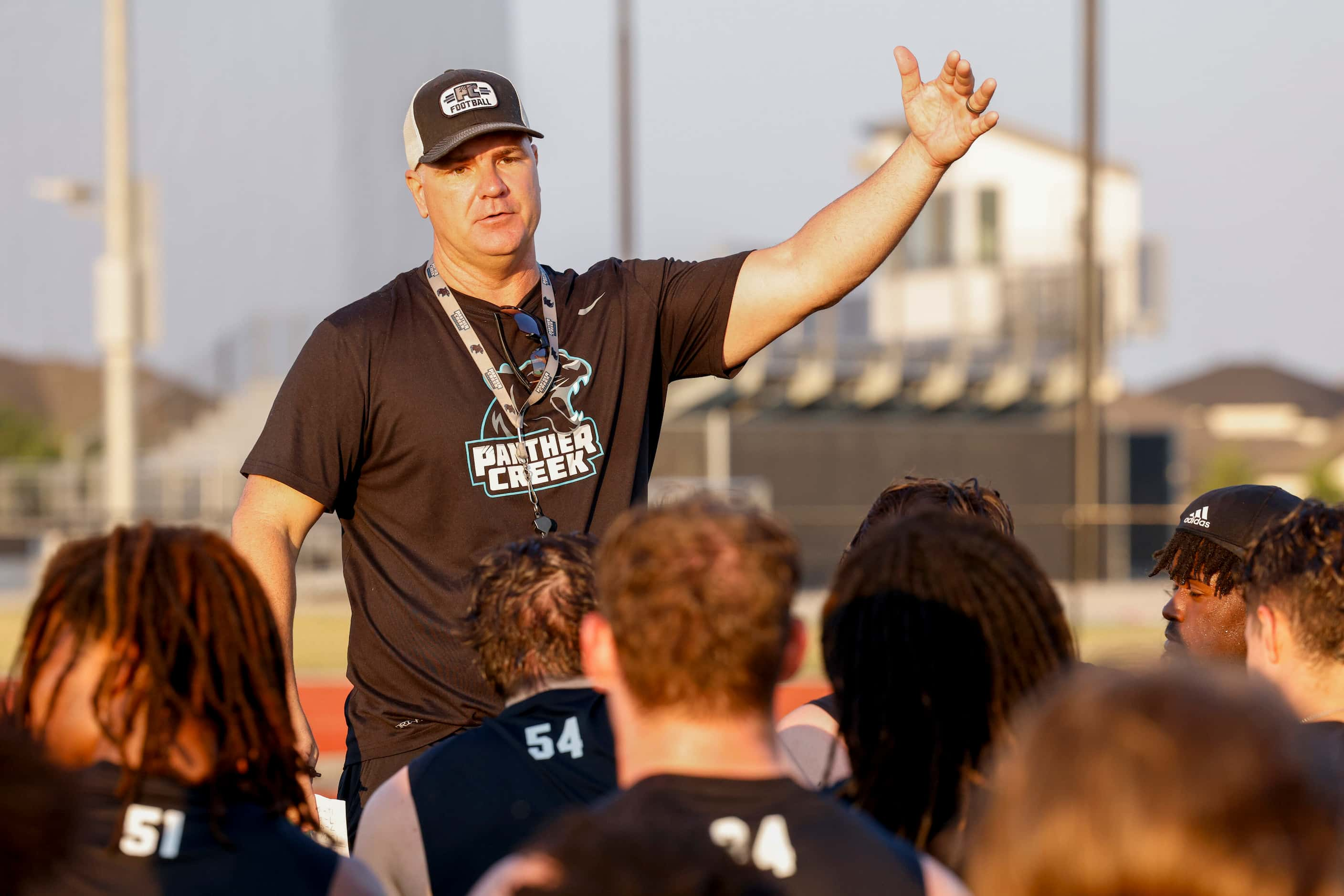 Head football coach Clint Surratt talks to players after the first day of practice at...