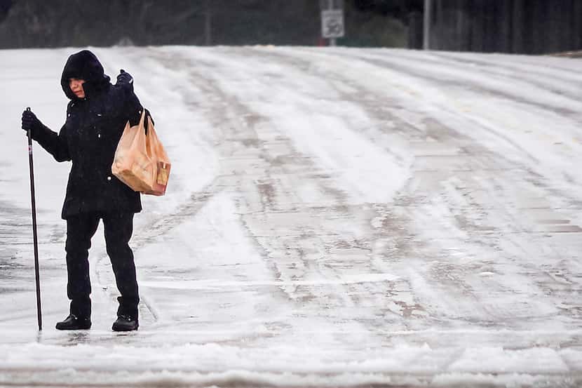 A woman carries bags of groceries while walking along Custer Parkway near Renner Road on...