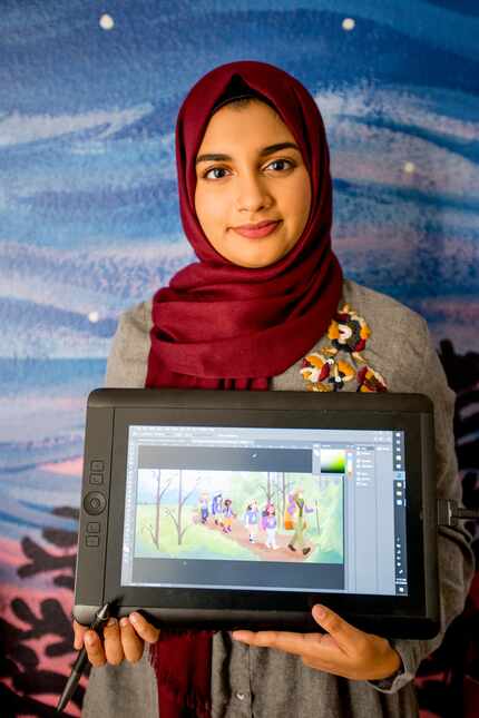 Aaliya Jaleel poses with a tablet displaying her work from Under My Hijab.