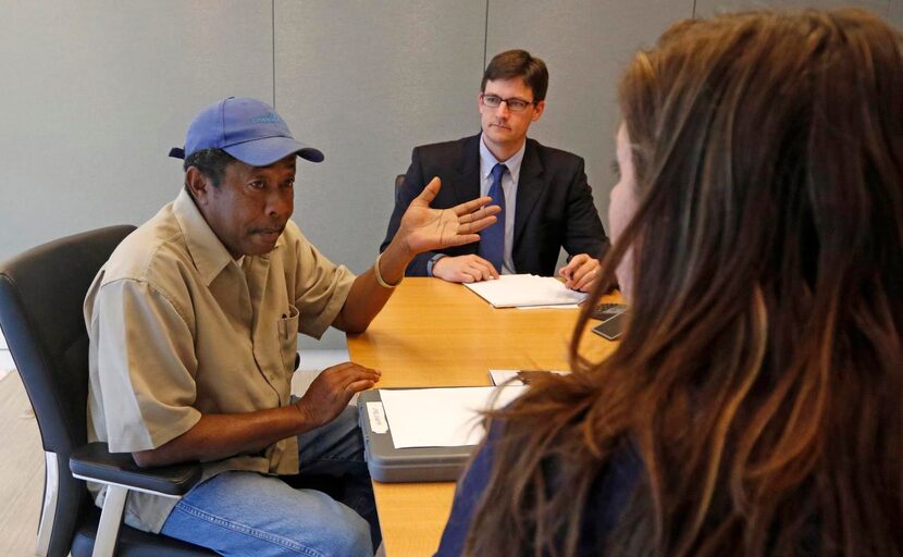 
Veteran Carl Guinn (left) talks to attorneys Derek Neilson and Stacie Cargill during the...