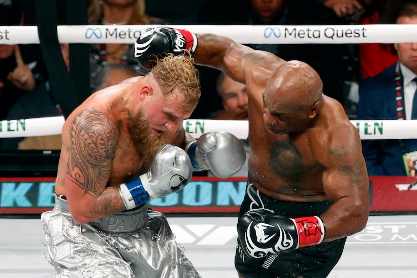 Mike Tyson throws a punch at Jake Paul during a heavyweight boxing match, Friday, Nov. 15,...