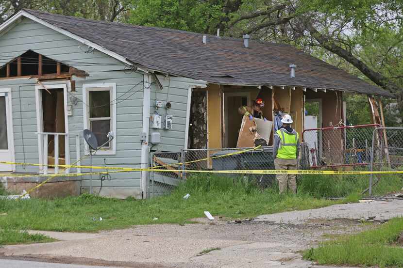 Officials investigate a house explosion at 3700 Spring Avenue in Dallas, near Fair Park, on...