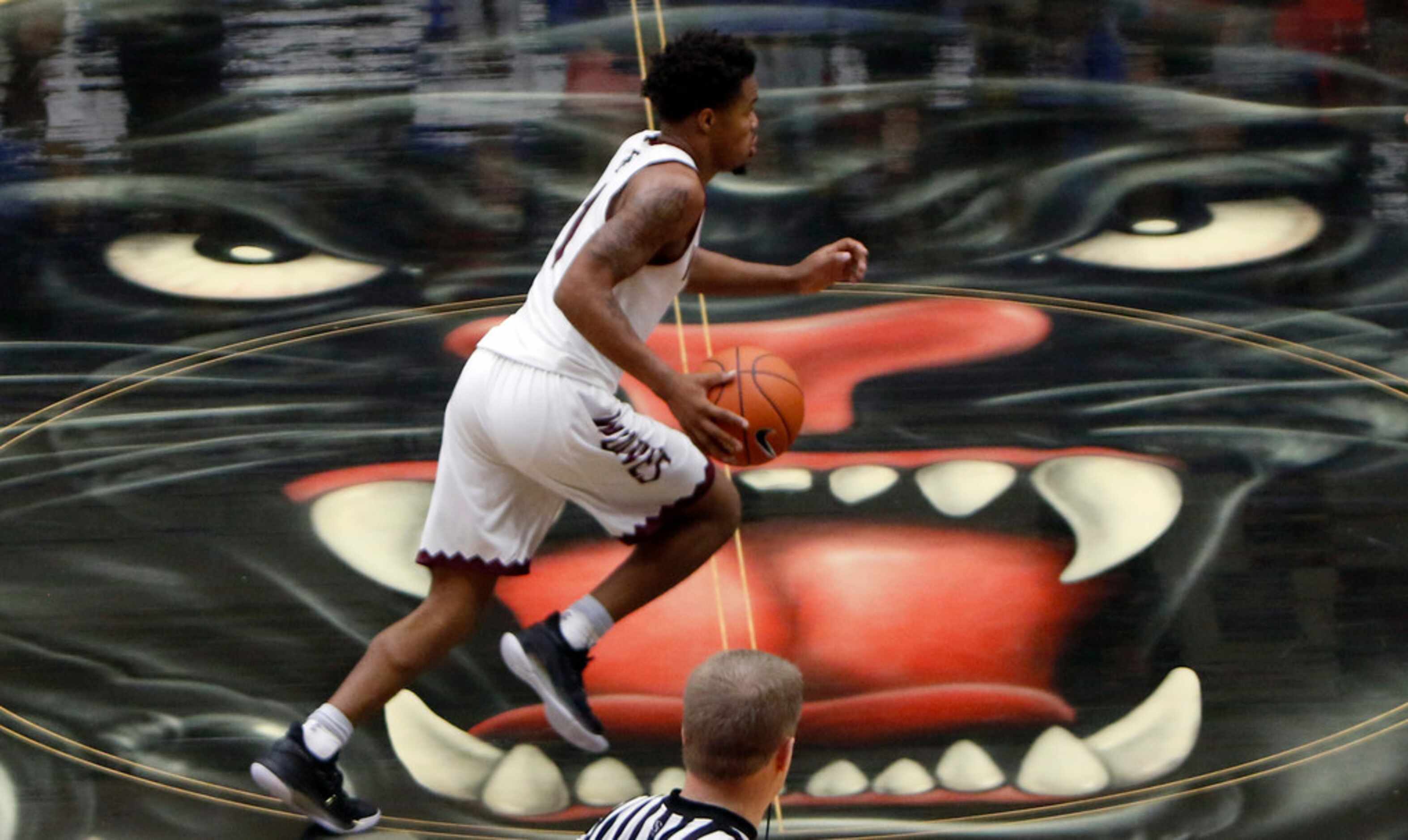 Mansfield Timberview senior Stacy Sneed (1) dribbles past mid-court as he sets up a play...