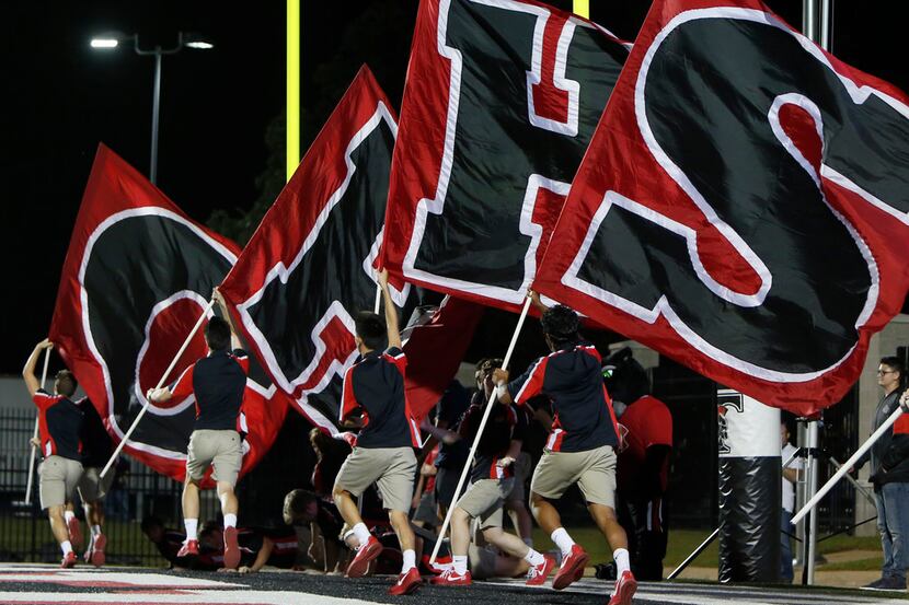 Colleyville Heritage flag wavers hit the field following a second quarter touchdown against...