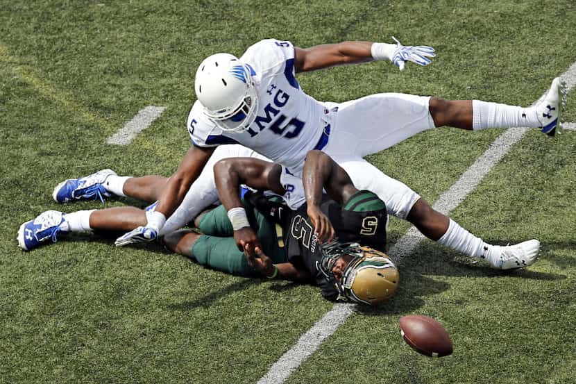 DeSoto's quarterback Tristen Wallace (5) fumbles the ball as he is brought down by IMG...