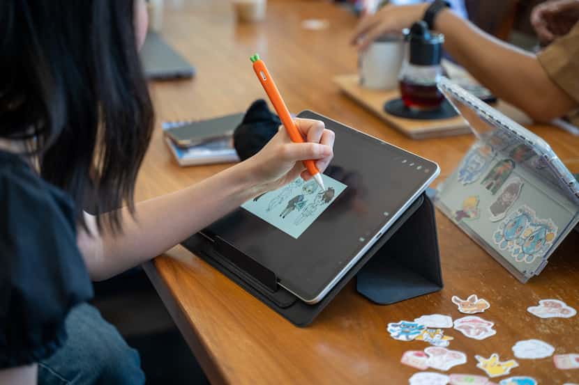 A Dallas Asian American Art Club member draws on a tablet during a weekly meeting Saturday,...