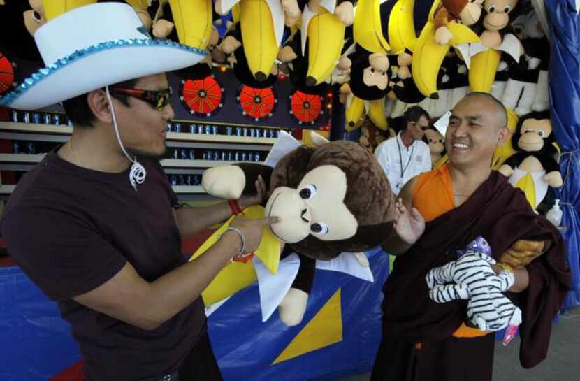 
Sporting a white cowboy hat and sunglasses, monk Gigmey Tenzin, (left), jokes with monk...