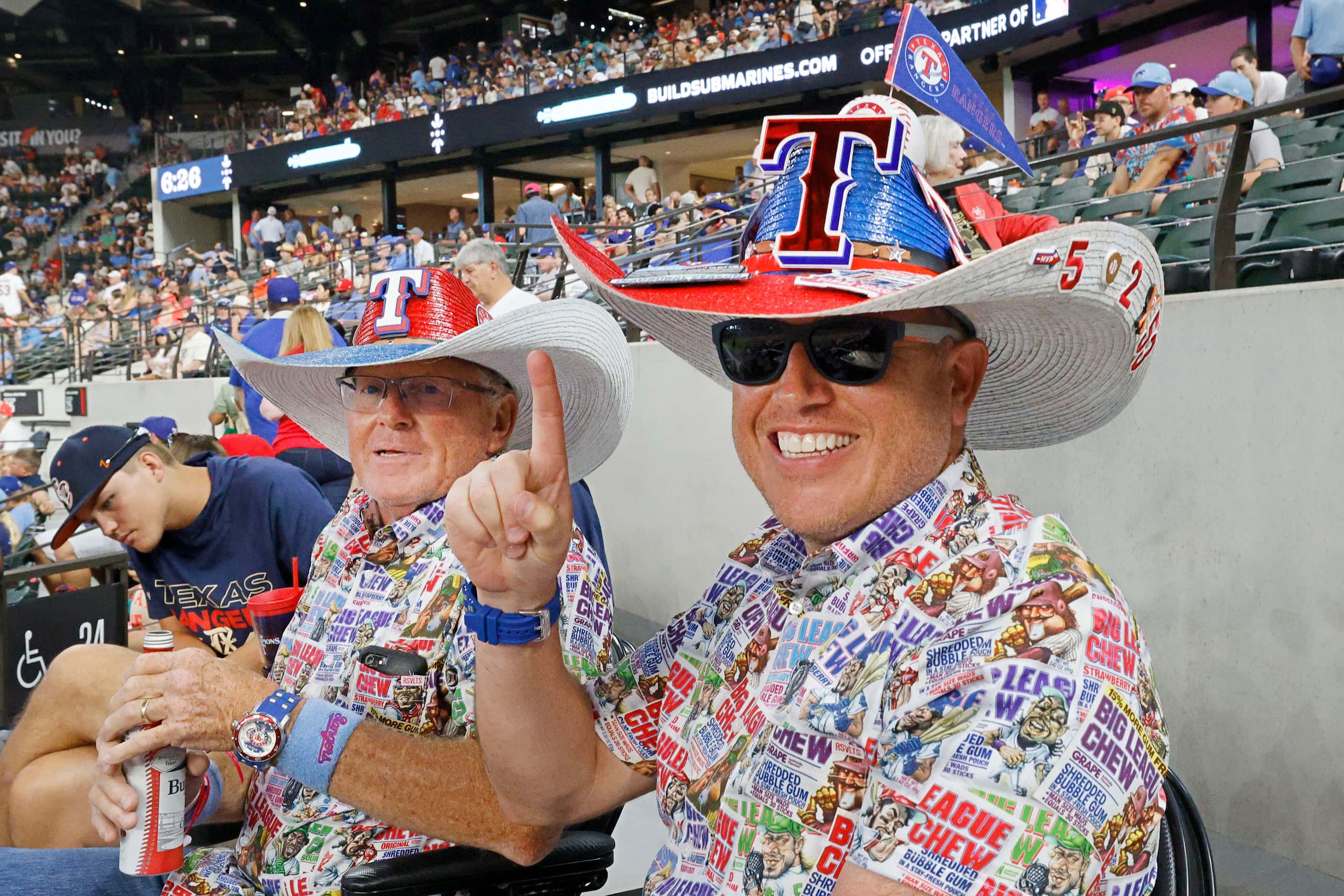 Texas Rangers fans Christopher Killion of Fort Worth and his father Galen Killion wear...