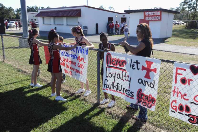 A Houston judge ruled Wednesday that Kountze High School cheerleaders could use Bible verses...
