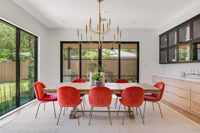 A dining room has large floor-to-ceiling windows that let in natural light.