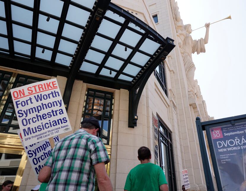 Striking Fort Worth Symphony musicians picket under the Bass Hall angels.