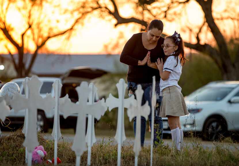 Meredith Cooper, of San Antonio, and her 8-year-old daughter, Heather, visit a memorial of...