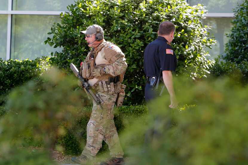 
A heavily-armed police officer walks around the perimeter of the Curtis Culwell Center...