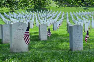 American flags are placed at the gravesites of service members buried at Arlington National...