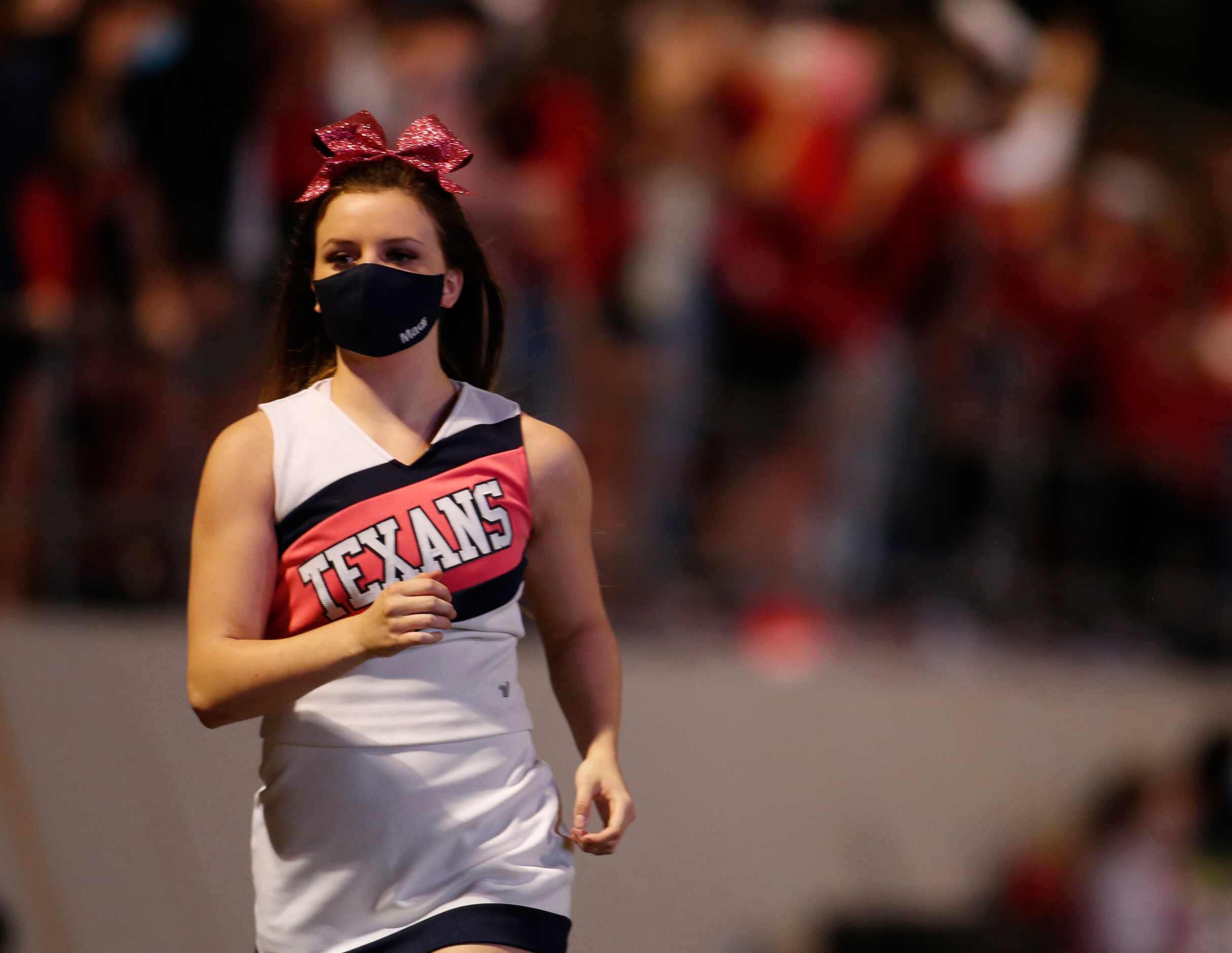 A member of the Northwest cheerleaders races to grab her flag for a celebration trip across...