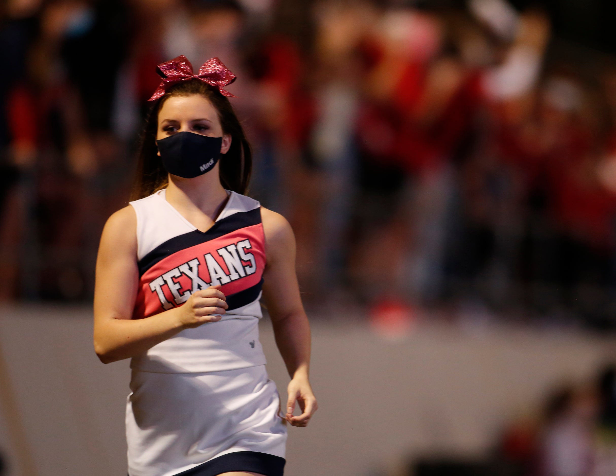 A member of the Northwest cheerleaders races to grab her flag for a celebration trip across...