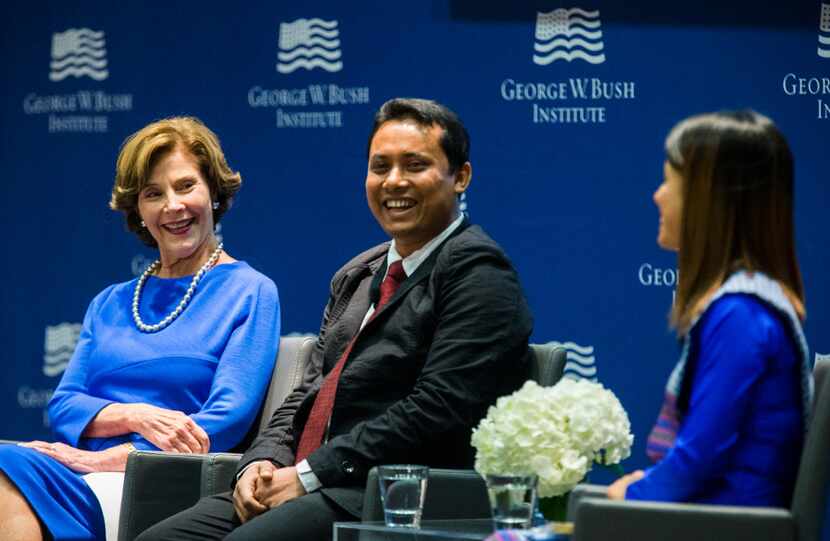 Former first lady Laura Bush speaks on a panel with graduates Aung Kyaw Moe (center) and Ei...