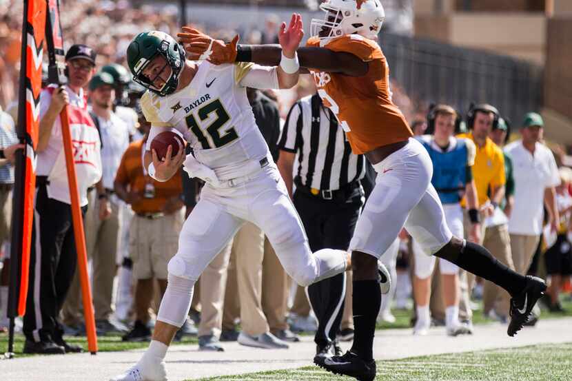 Baylor Bears quarterback Charlie Brewer (12) is pushed out of bounds by Texas Longhorns...