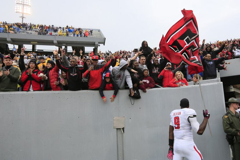 Texas Tech's Shawn Corker (9) carries their flag in front of their fan section following...