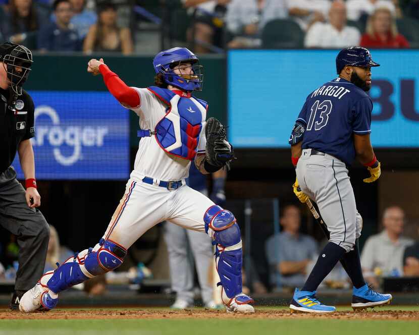 Texas Rangers catcher Jonah Heim (28) fakes a throw to second base alongside Tampa Bay Rays...