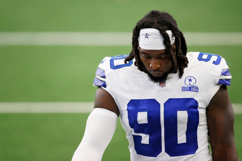 Dallas Cowboys defensive end DeMarcus Lawrence (90) makes his way off the field after losing...