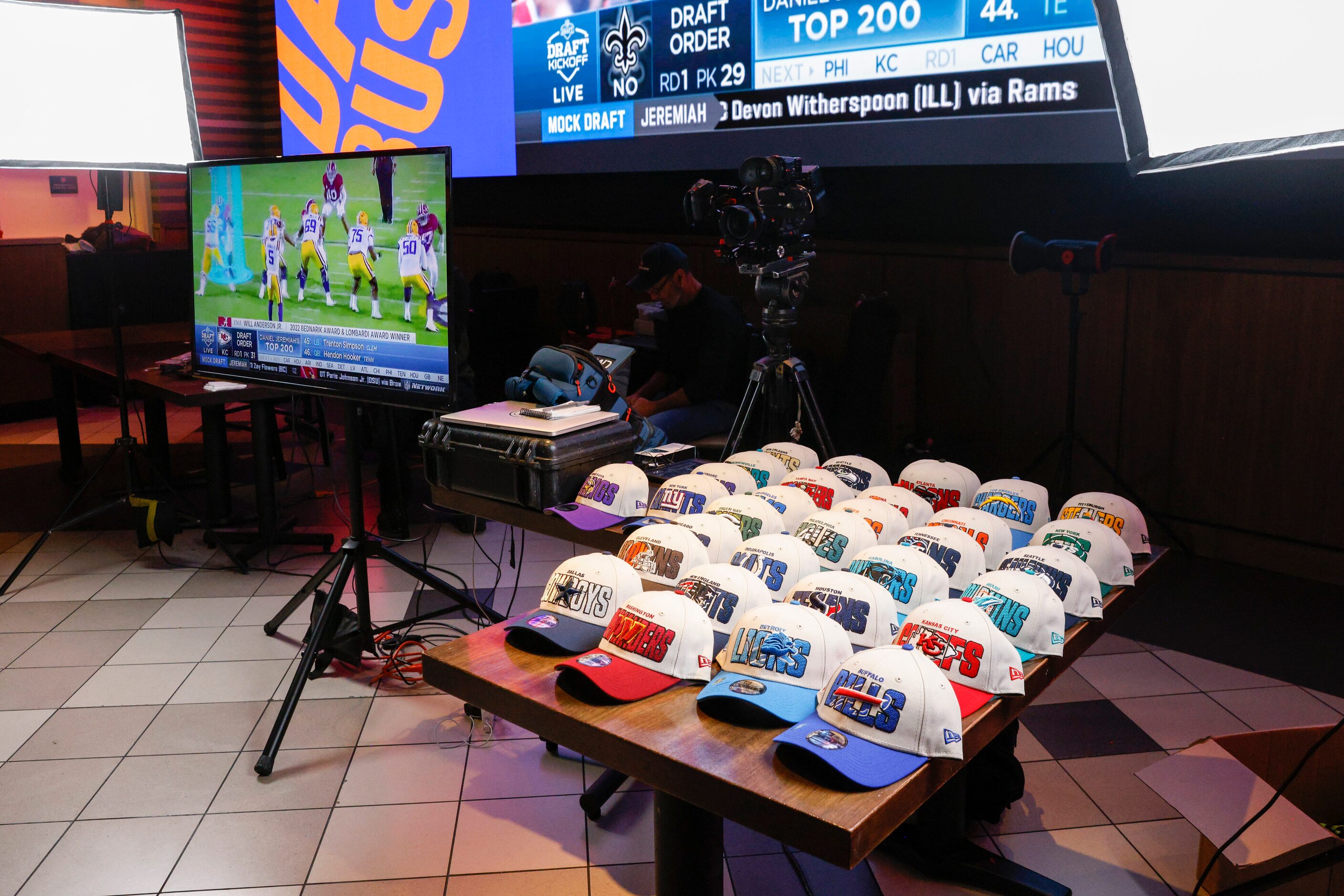 Hats for every NFL team sit on a table during a 2023 NFL Draft party for TCU wide receiver...