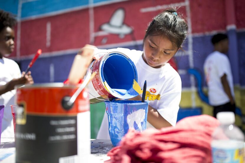 Brille Yanez, de 8 años ayuda a su hermano Daniel, quien diseñó el mural para el Boys &...