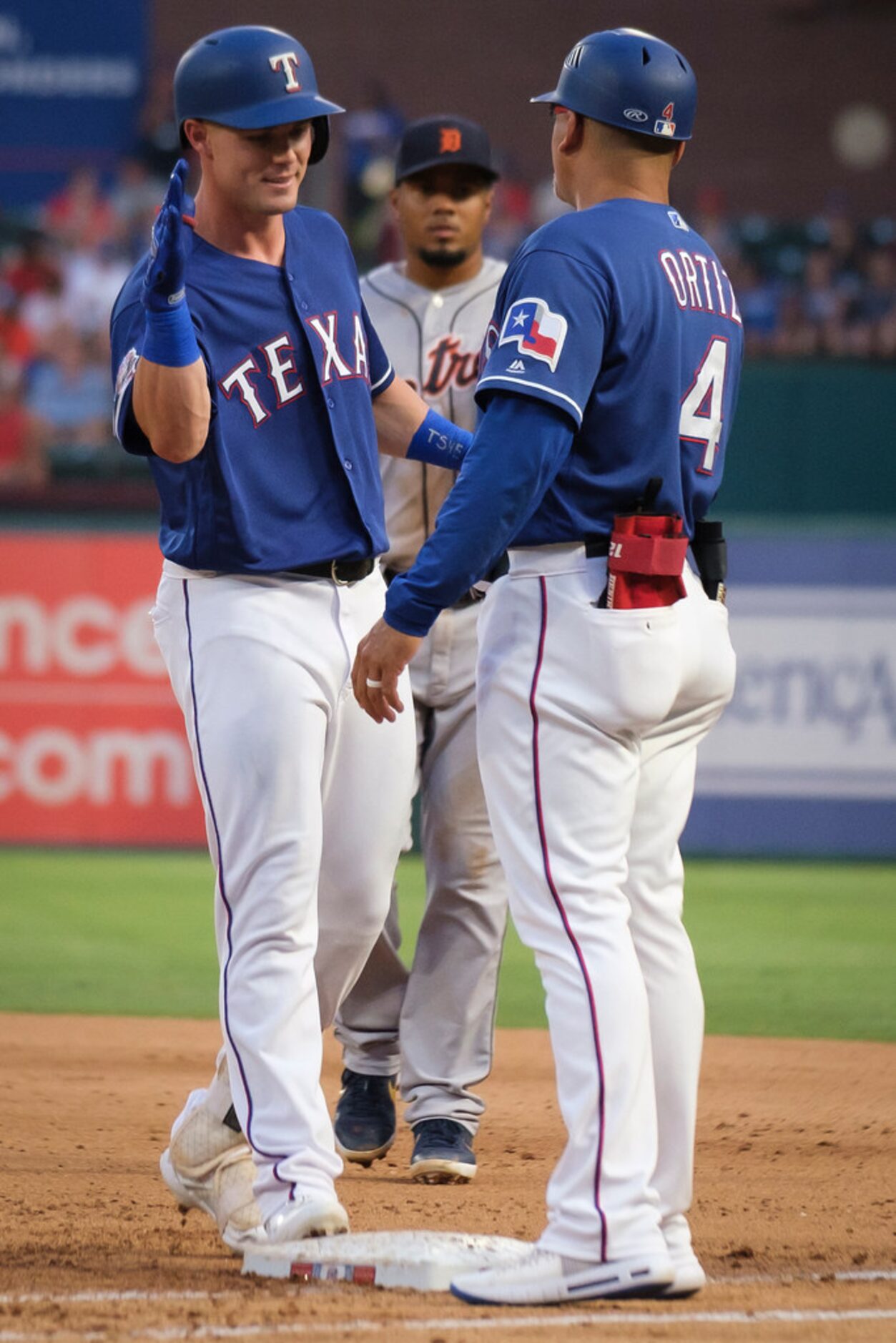 Texas Rangers outfielder Scott Heineman celebrates with first base coach Hector Ortiz after...