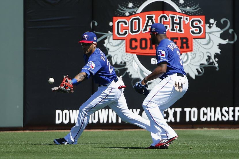 Ian Desmond (left) and Delino DeShields are unable to make a play on a fly ball hit by Jacob...