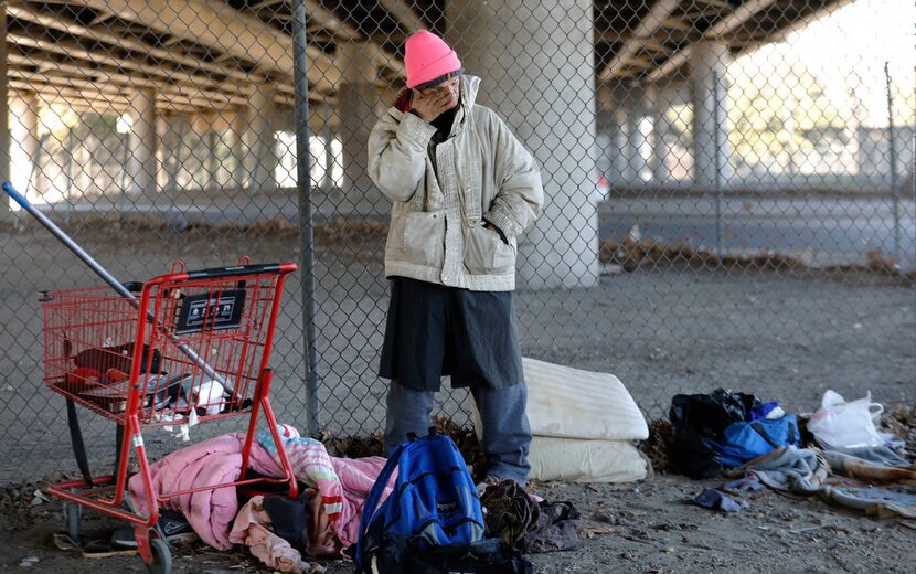 Tracy Larue, 48, stands next to the personal belongings of an elderly homeless man who was...