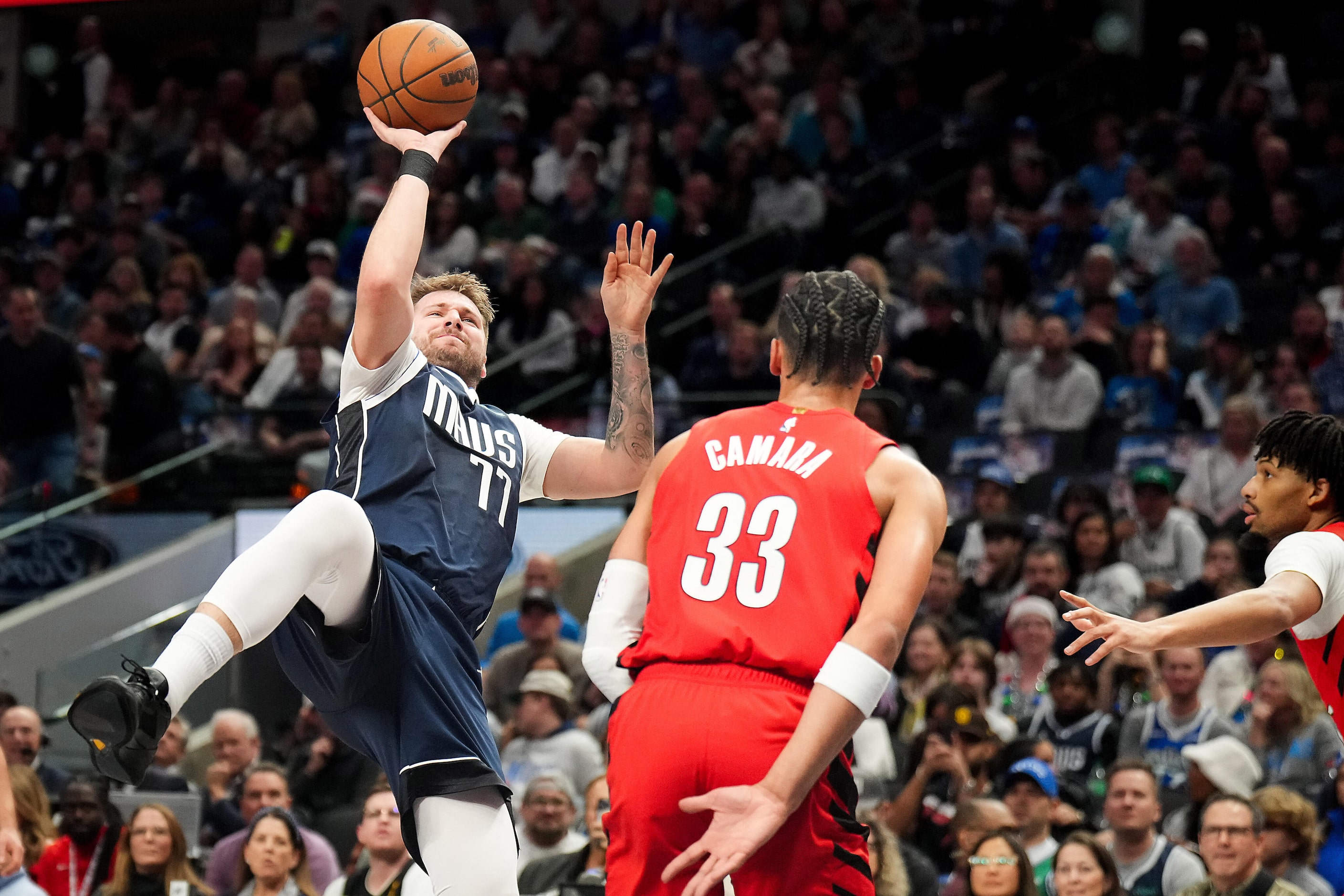 Dallas Mavericks guard Luka Doncic (77) puts up a shot as he is fouled by Portland Trail...