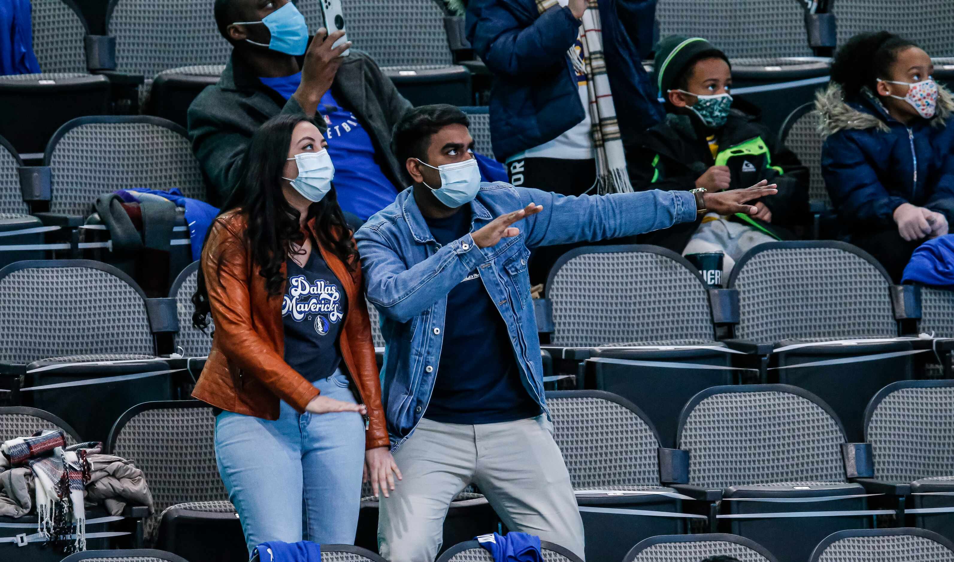 Fans, consisting mostly of healthcare workers, dance for the fancam during an NBA basketball...