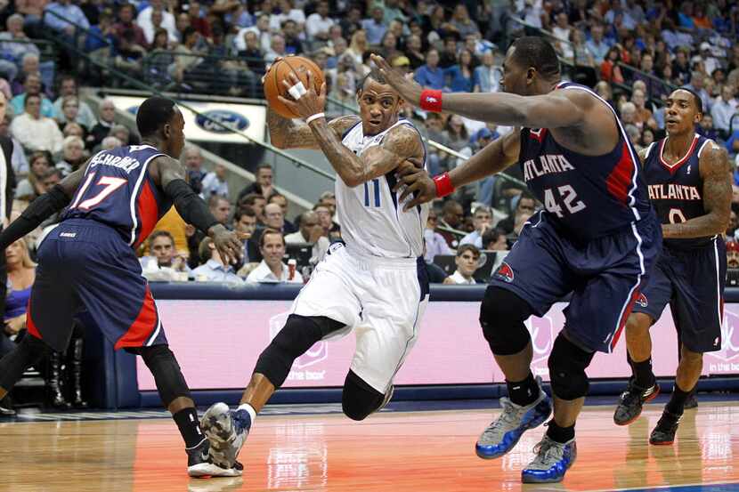 Dallas Mavericks shooting guard Monta Ellis (11) drives to the basket between Atlanta Hawks...