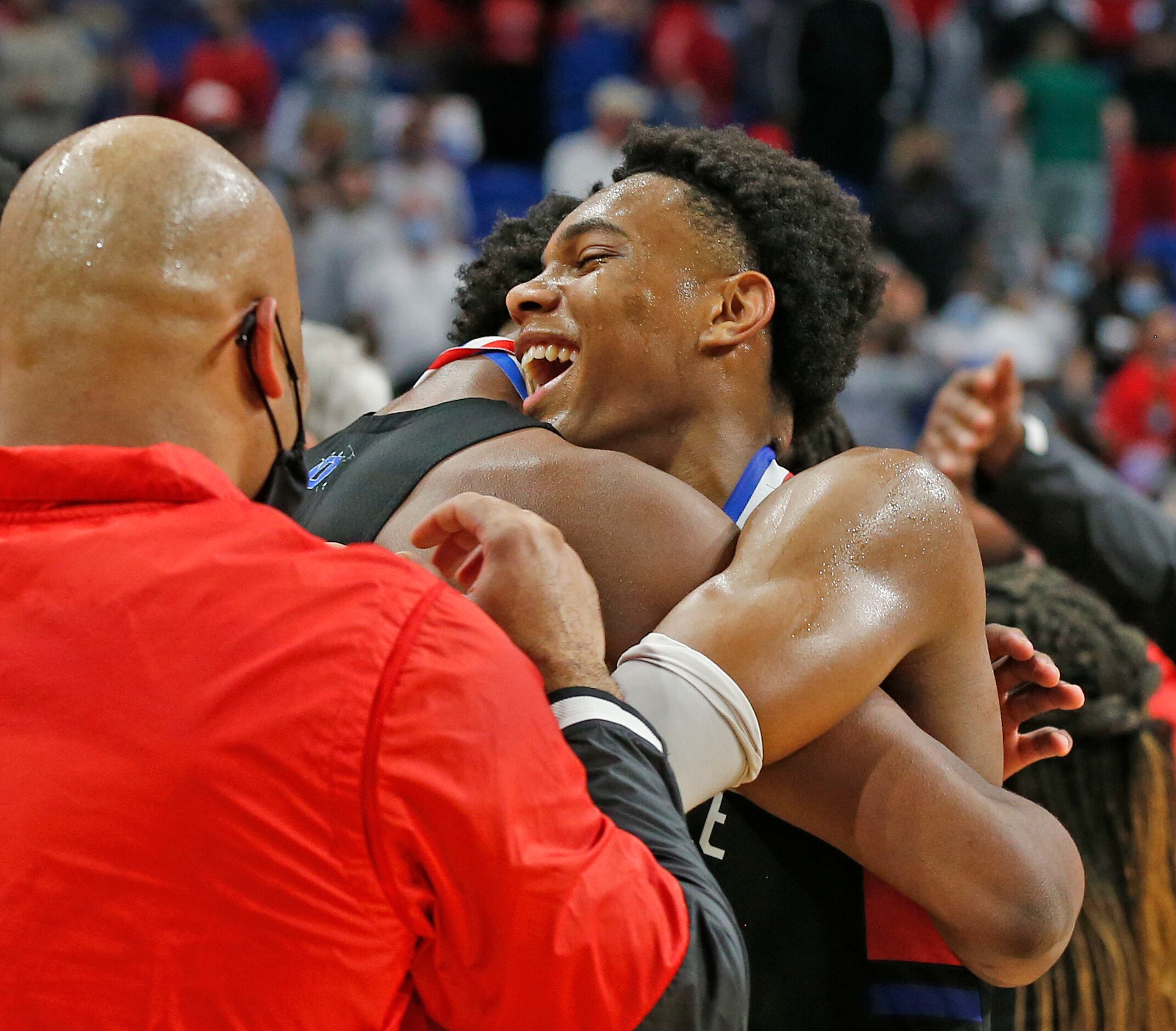 Duncanville Zhuric Phelps #0 is hugged by teammates. UIL boys Class 6A basketball state...