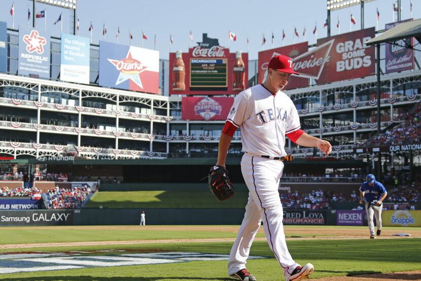 Texas Rangers starting pitcher Derek Holland (45) walks off the field after being pulled in...