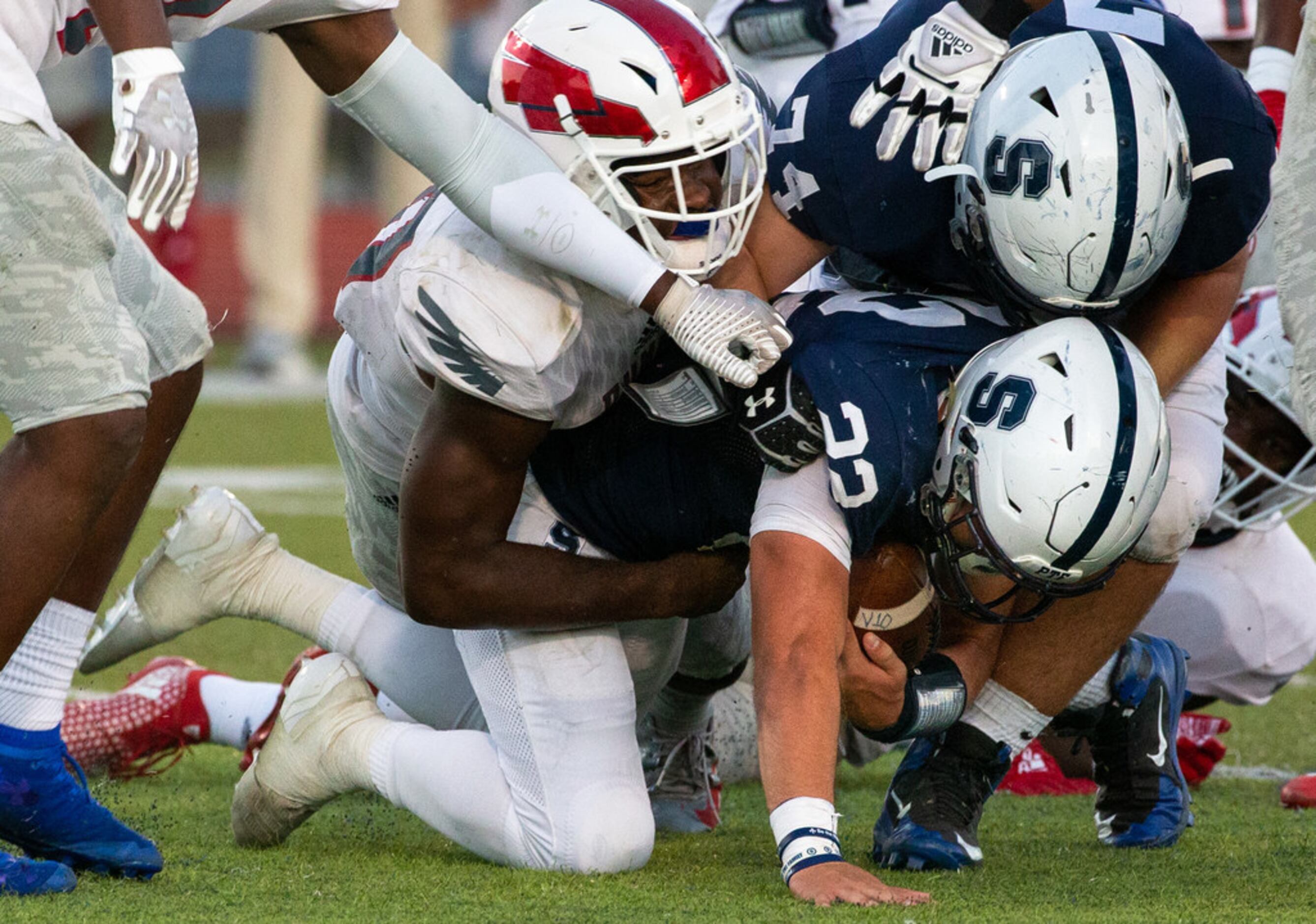 All Saints' Episcopal running back Jacob Matlock (22, center) gets sacked by Bishop Dunne...