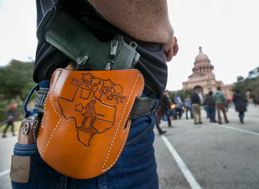  Terry Holcomb,executive director of Texas Carry, happily displays his customized holster as...