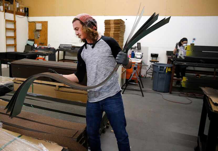 TEK Industries worker Skylor Thiebaud grabs a stack of stone-coated trim flat sheets for...