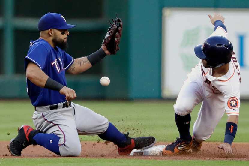 Houston Astros' Jose Altuve, right, steals second base as Texas Rangers second baseman...
