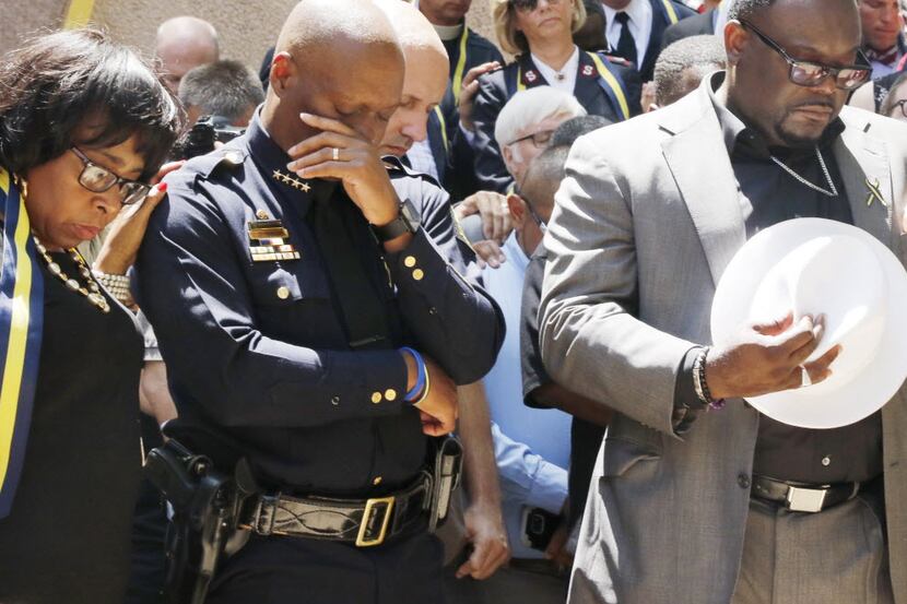 Dallas Police Chief David Brown, center, pauses at a prayer vigil during a citywide prayer...