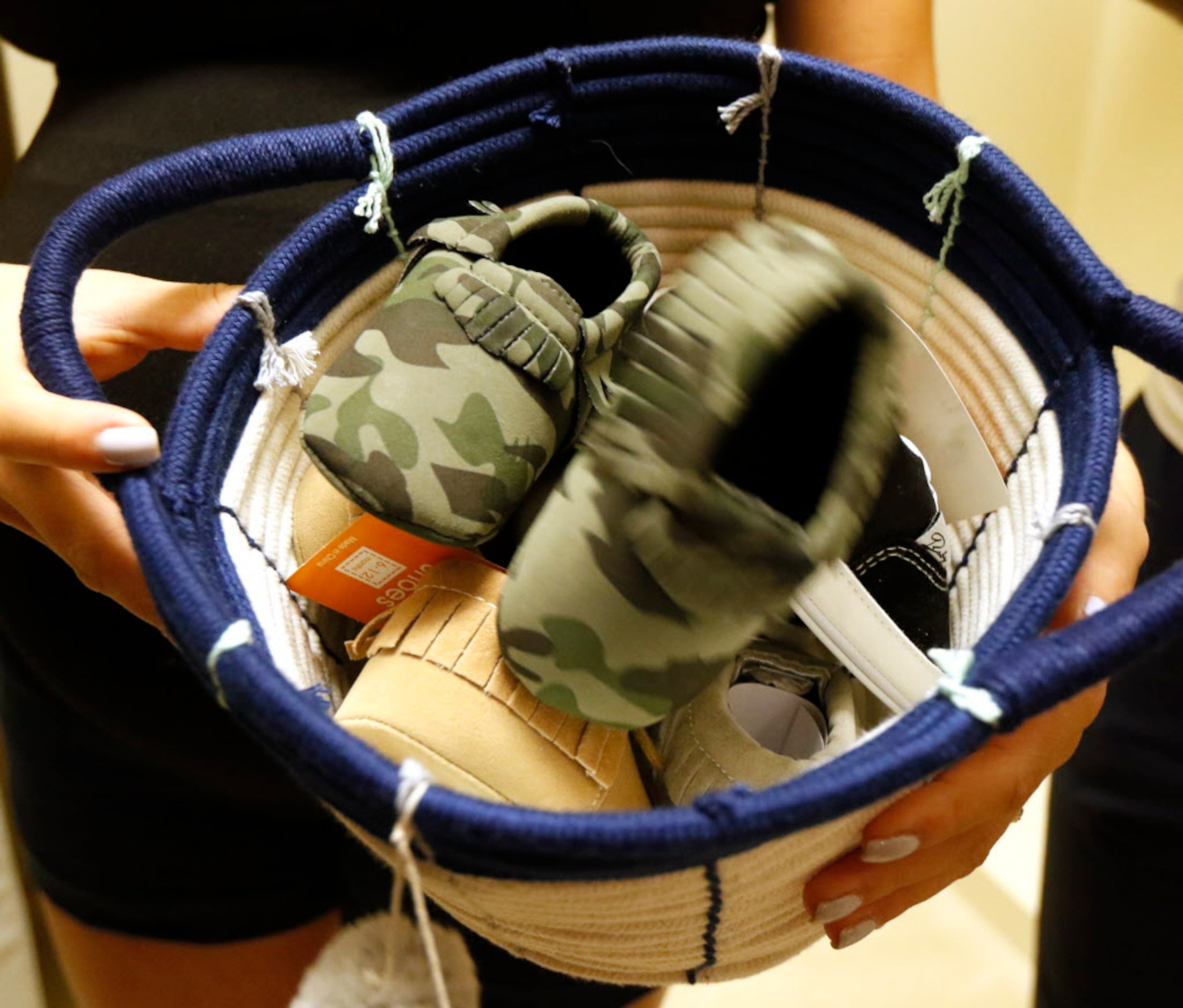 Cori Andrus holds a basket of baby shoes in the nursery at their home in Frisco, Texas on...