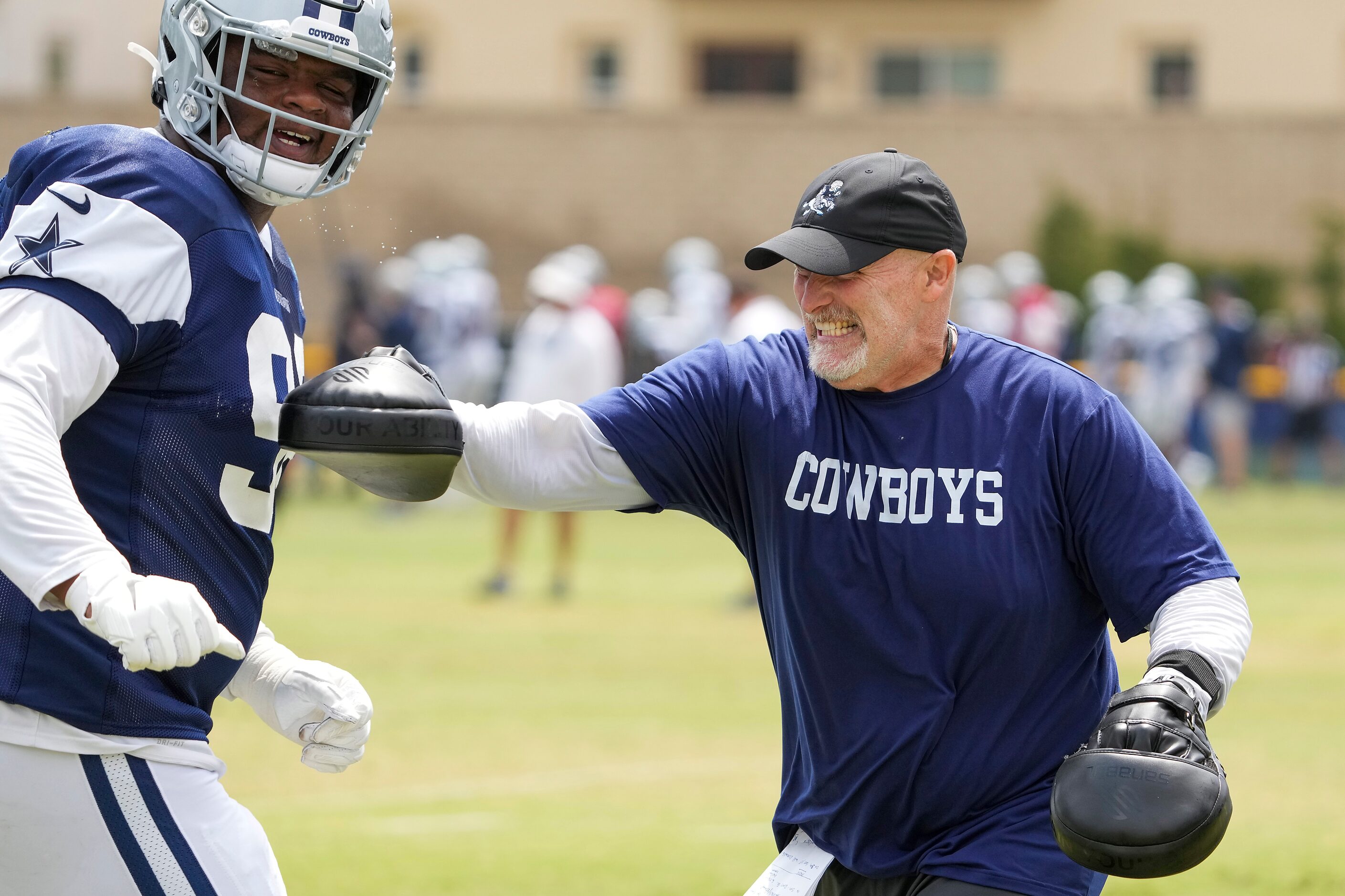 Dallas Cowboys defensive coordinator Dan Quinn works with defensive tackle Quinton Bohanna...